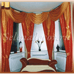 Горизонтальные жалюзи белого цвета в эркерном окне гостиной, верх оформлен яркими шторами со сложным ламбрекеном